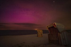 Polarlicht über Strandkörben am Strand von Stein in Schleswig-Holstein